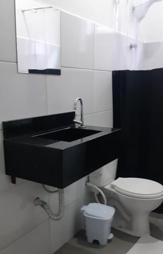 ein Badezimmer mit schwarzem Waschbecken und Toilette in der Unterkunft Hotel Tomazina in Tomazina