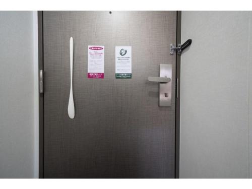 a door in a bathroom with signs on it at R&B Hotel Hakata Ekimae 2 - Vacation STAY 40722v in Fukuoka