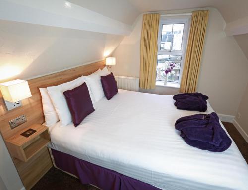 a bedroom with a large white bed with a window at The Chocolate Box Guest House in Bournemouth