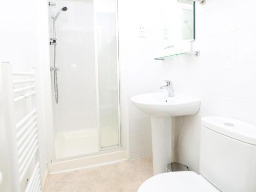 a white bathroom with a shower and a sink at The Chocolate Box Guest House in Bournemouth