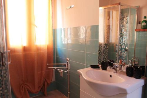La salle de bains est pourvue d'un lavabo et d'une douche. dans l'établissement B&B la piccola maison, à Ploaghe