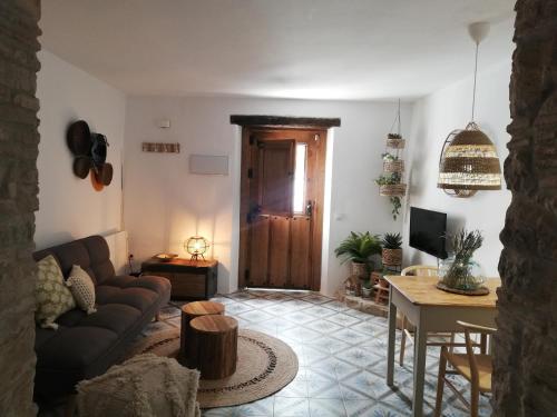 a living room with a couch and a table at Casa Romántica con Sauna privada Eternal Rural in Jimena de la Frontera