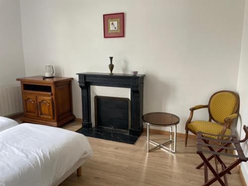 - une chambre avec une cheminée, deux chaises et un lit dans l'établissement Gîtes des châteaux - gite A, à Selles-sur-Cher
