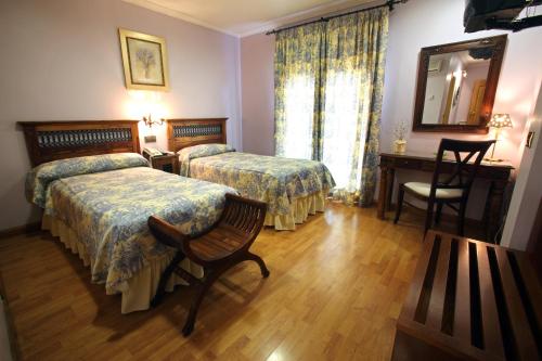 a hotel room with two beds and a mirror at Hotel El Pentágono in Muñana