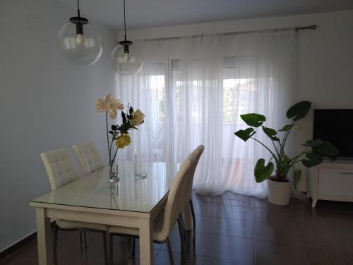a dining room table with a vase of flowers on it at La Carbonera in Sanlúcar de Guadiana