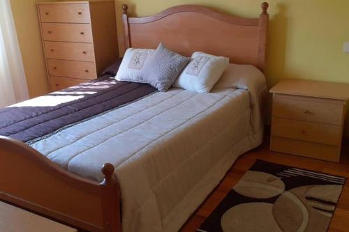 - une chambre avec un grand lit et une tête de lit en bois dans l'établissement CASA CON PISCINA Y BARBACOA, à Freigido