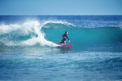 a man riding a wave on a surfboard in the ocean at Casamar, beach front estate on Troncones Point in Troncones