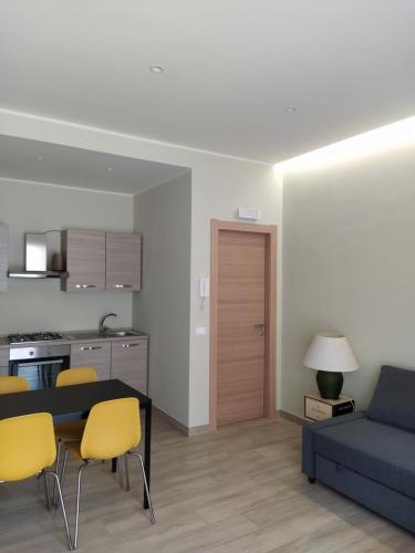 sala de estar con sofá azul y sillas amarillas en Gelsonero Apartments, en Ragalna