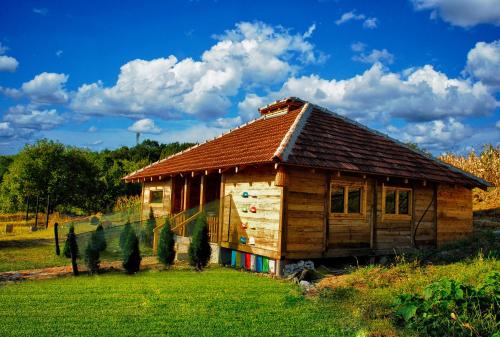 una pequeña casa de madera en un campo de hierba en Bungalovi api-centar, en Gornji Milanovac
