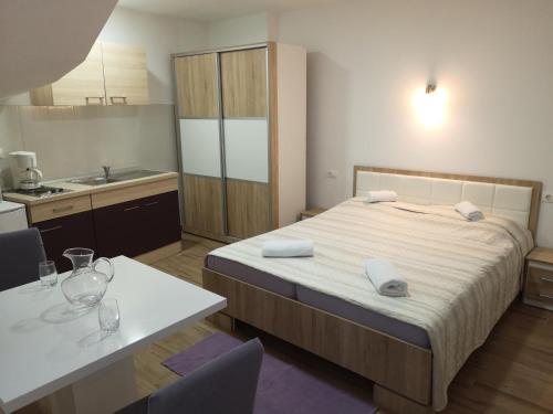 a small bedroom with a bed and a kitchen at Apartmani Maki in Omiš
