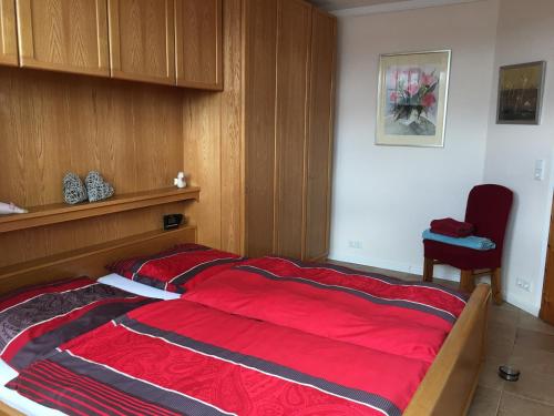 una camera da letto con un grande letto con una coperta rossa di Ferienwohnung Panoramablick Ennepetal a Ennepetal