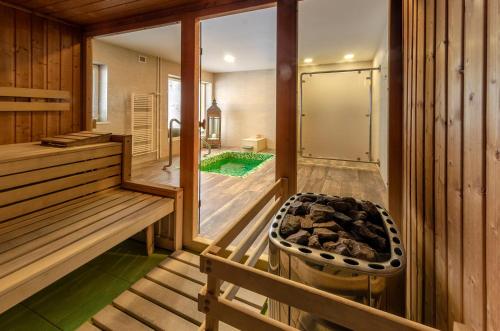 a room with a sauna with a bench and a tub at Hotel Granit Smrekovica in Liptovská Osada