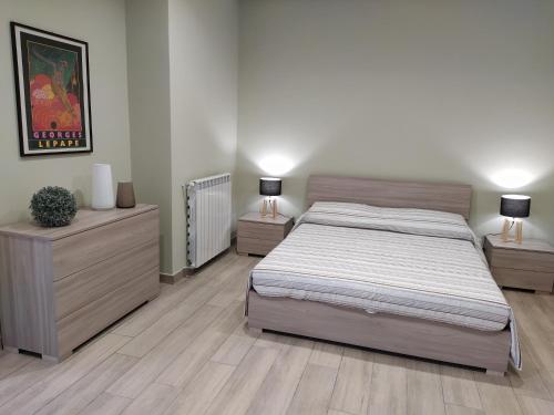 - une chambre avec un grand lit et 2 tables de chevet dans l'établissement Gelsonero Apartments, à Ragalna