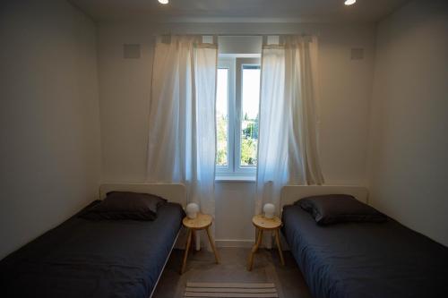 - 2 lits dans une chambre avec fenêtre dans l'établissement Apartman SENKA, à Biograd na Moru