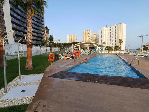 a large swimming pool in a city with buildings at Sunset Waves Benidorm by KalmaRent in Benidorm