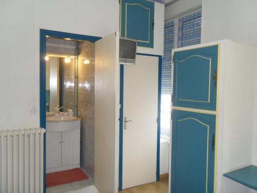 a bathroom with blue and white doors and a sink at Hotel Durand Le Patio in Alès