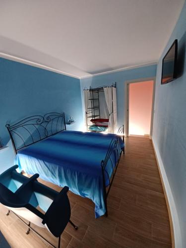 a blue bedroom with a bed and a chair at La Casina in Salaiola