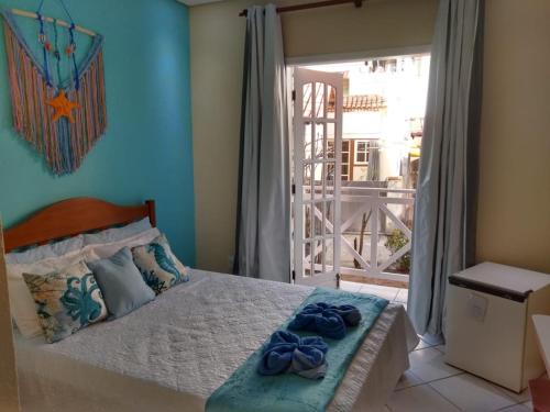 a bedroom with a bed with two blue towels on it at Pousada Arrastão da Ilha in Abraão
