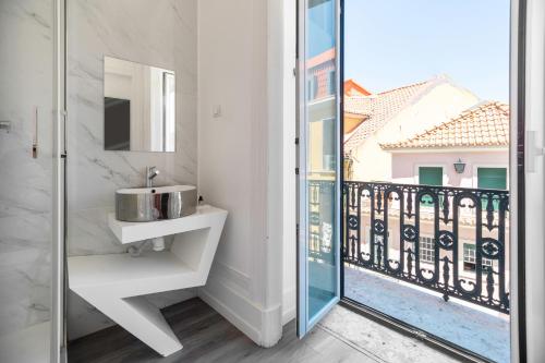 a bathroom with a sink and a balcony at The Hygge Lisbon Suites - Estrela in Lisbon