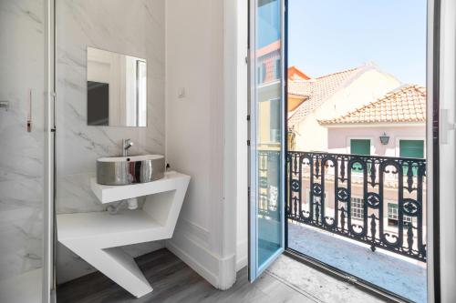 uma casa de banho com um lavatório e uma varanda em The Hygge Lisbon Suites - Estrela em Lisboa