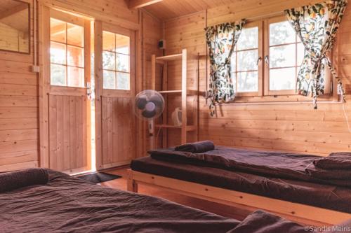 a bedroom with two beds in a log cabin at Viesu nams “Bauļi” in Ventspils