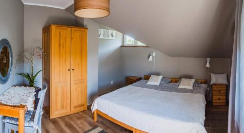 a bedroom with a bed and a wooden cabinet at Dom gościnny Szulcówka in Swornegacie 