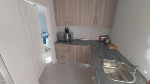a kitchen with a sink and a counter top at Cottage self catering unit with ensuite. in East London