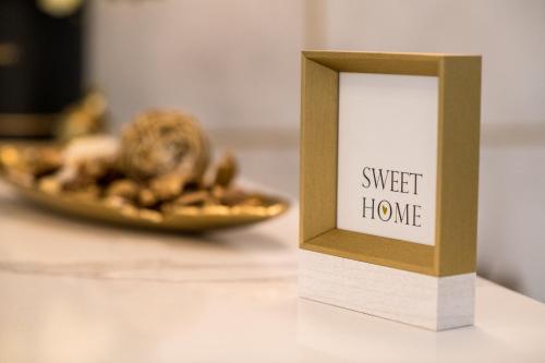 a box with a sign that reads sweet home next to a plate of food at Arletti Hotel in Ruse
