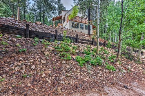 a house on a hill with a fence at On the Rocks - A Modern Home with Decks and Views in Cloudcroft