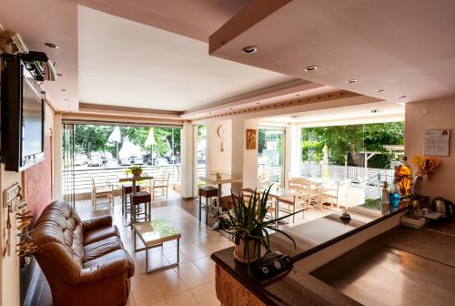 sala de estar con sofá, mesa y sillas en Stefanidis Platani Beach, en Stavros