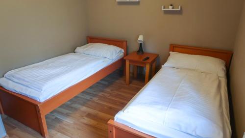 2 aparte bedden in een kamer met een nachtkastje bij Apartmány Doky - PLA in Lipno nad Vltavou