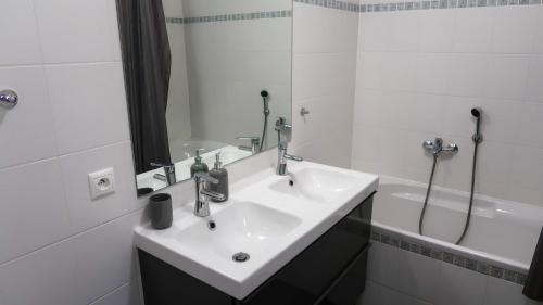 een witte badkamer met een wastafel en een douche bij Apartmány Doky - PLA in Lipno nad Vltavou