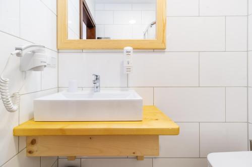 a bathroom with a white sink and a mirror at Stachelisko - domki i pokoje in Chochołów