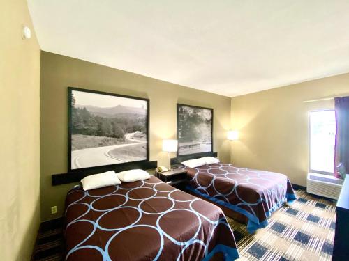 a hotel room with two beds and two windows at Super 8 by Wyndham Conway in Conway