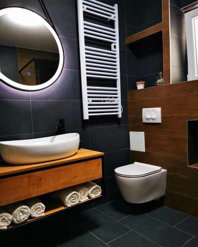 a bathroom with a sink and a toilet and a mirror at Villa Black&White in Kastel Sucurac