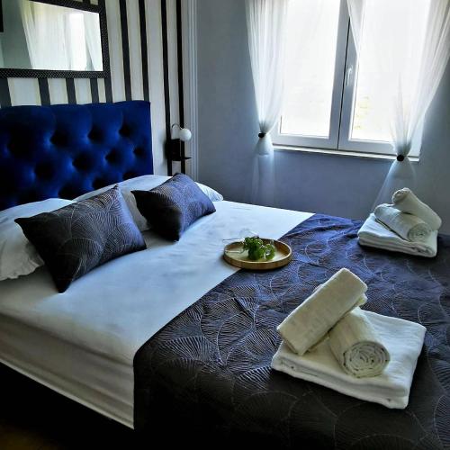 a bed with towels and a plate of food on it at Villa Black&White in Kastel Sucurac