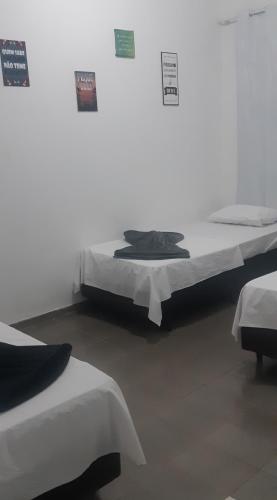 zwei Betten in einem Zimmer mit Schildern an der Wand in der Unterkunft Hotel Tomazina in Tomazina