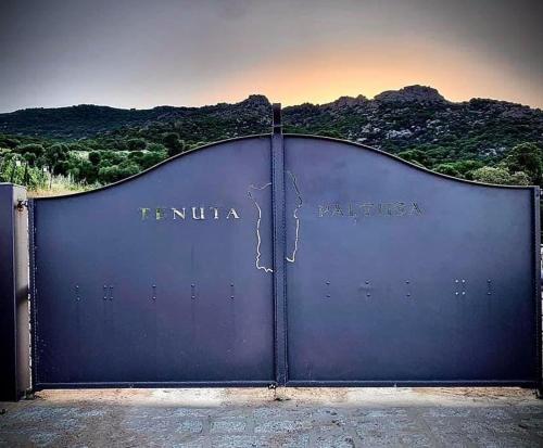 a large metal gate with the words temula patricias at Tenuta Paltusa in Calangianus