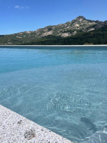 a large body of water with a mountain in the background at Tenuta Paltusa in Calangianus