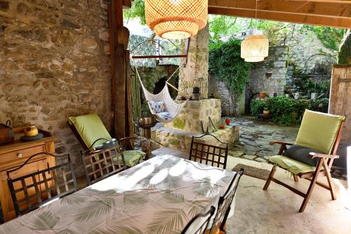 a bedroom with a bed and chairs in a room at Le Bruit de l'Eau (Chambre Loft) in Labeaume