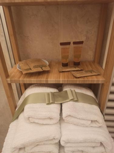 een plank met handdoeken en twee kopjes in een badkamer bij L'Angelo pellegrino miniappartamenti in Rieti