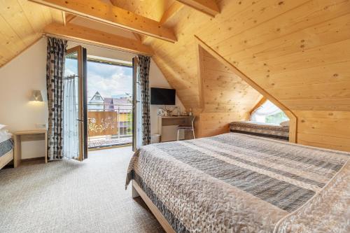 a bedroom with a bed and a large window at Stachelisko - domki i pokoje in Chochołów