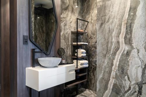 a bathroom with a sink and a stone wall at Theatre Hotel in Olomouc
