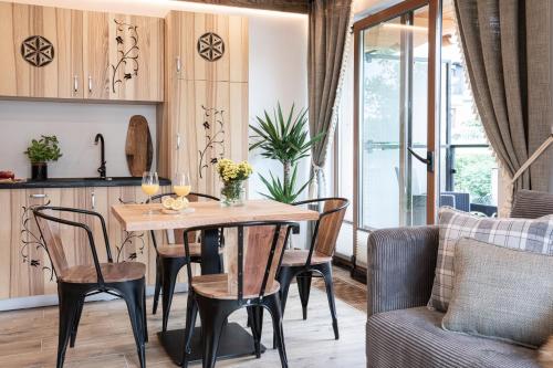 a kitchen with a dining room table and chairs at Apartamenty Koziniec in Zakopane