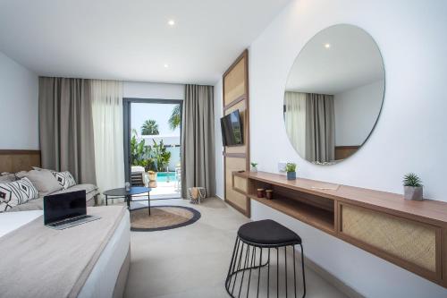 una camera d'albergo con un grande specchio e un letto di Vanik Suites a Calitea (Kallithea)