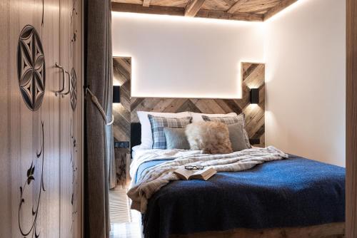 a bedroom with a blue bed with a wooden wall at Apartamenty Koziniec in Zakopane