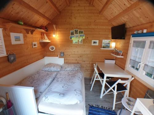 a bedroom with a bed and a desk in a cabin at Tinyhouse am Fluss in Otterndorf