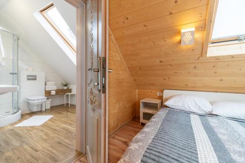 a bedroom with a bed and a bathroom at Stachelisko - domki i pokoje in Chochołów