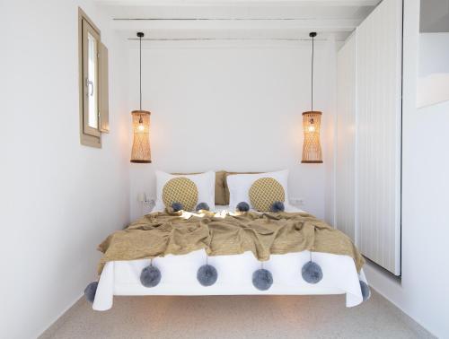a bedroom with a white bed with two lamps at Due Mari Mykonos in Agios Ioannis Mykonos