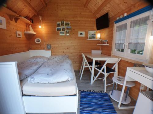 a bedroom with a bed and a table in it at Tinyhouse am Fluss in Otterndorf
